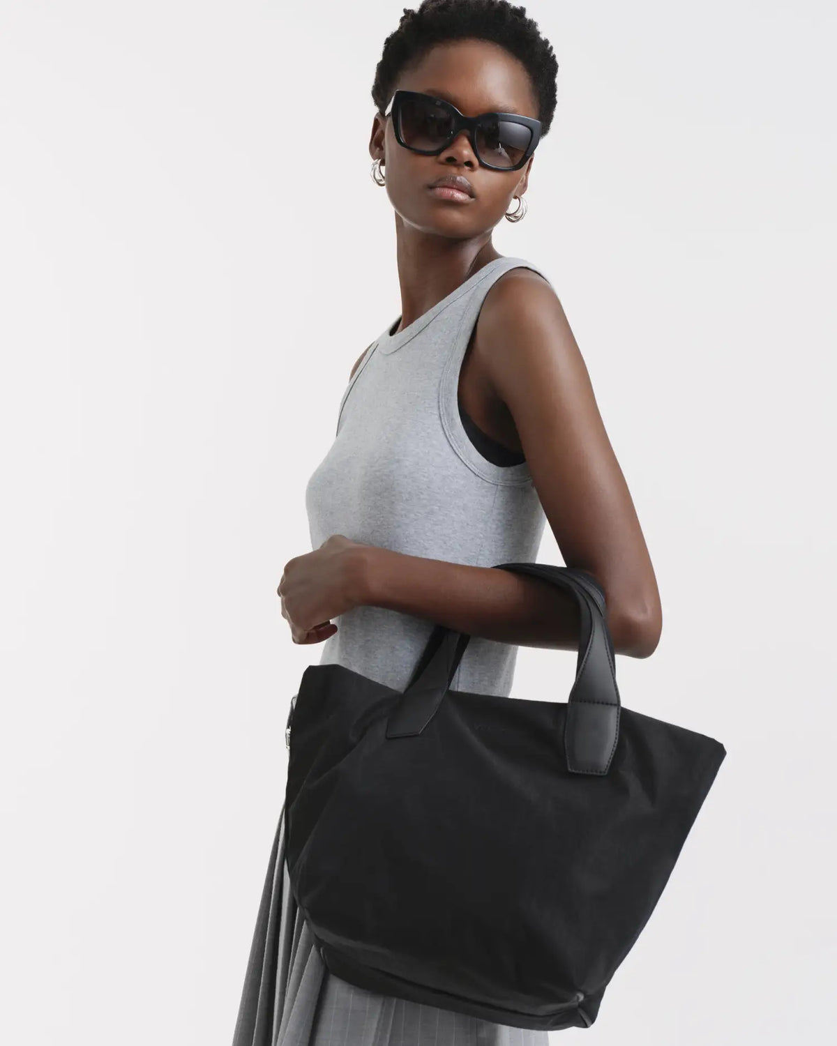 Porter Essence Small Black Paper bag held by model, featuring sustainable paper touch nylon design.