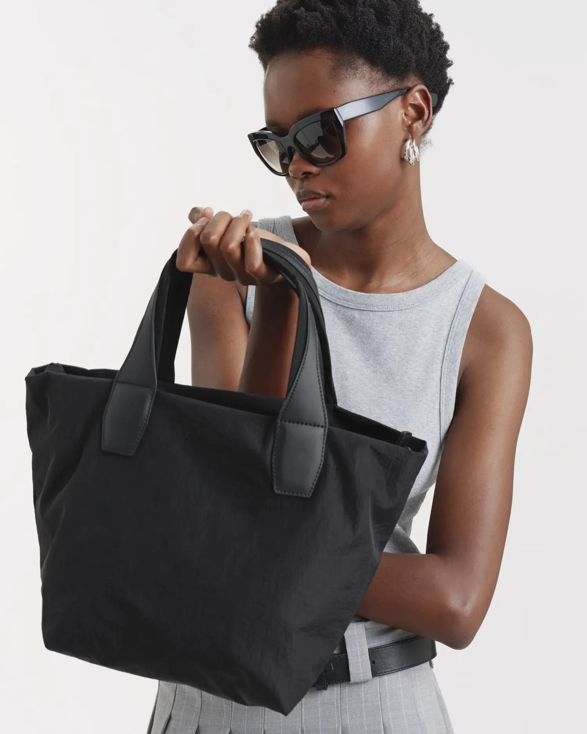 Porter Essence Small Black Paper bag made of sustainable paper touch nylon, shown in a stylish pose.