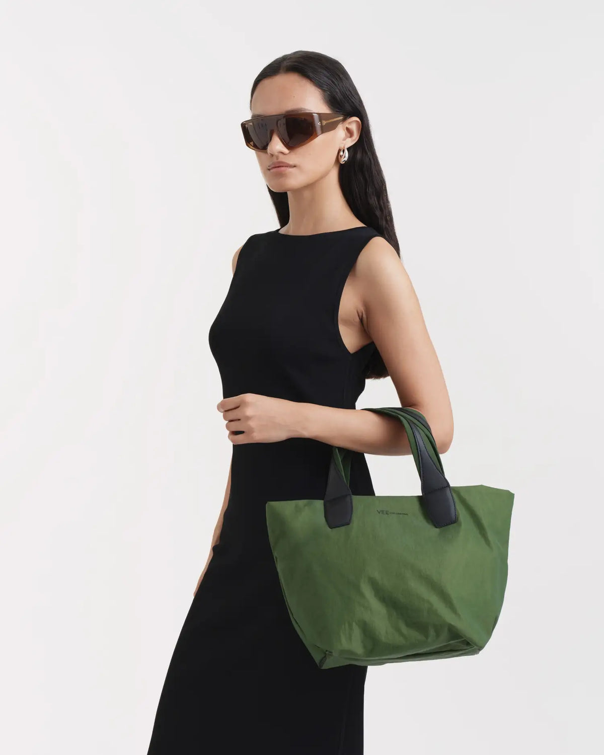 Porter Essence Small Olive Paper bag showcased by a model, featuring paper touch material and a minimalistic design.