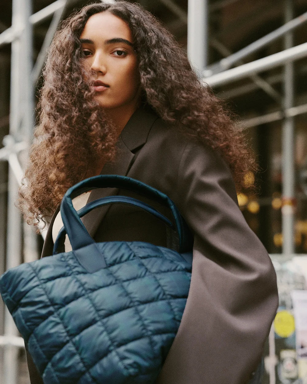Woman holding quilted Porter Tote bag in Ivy Plaid in an urban setting
