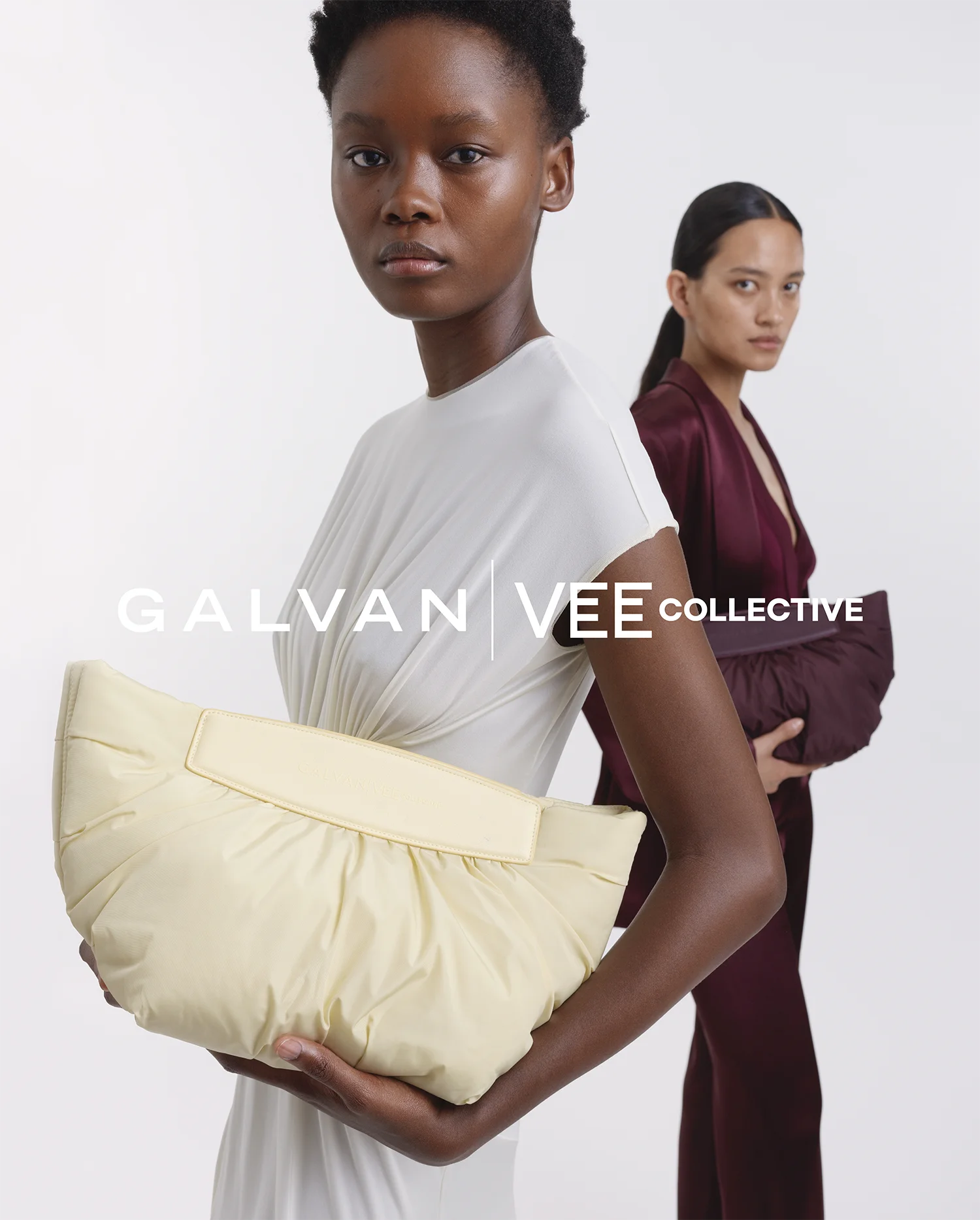 Two women standing in an elegant setting. One wears a mahogany-colored outfit and holds the Galvan x Vee Collective Caba Clutch in mahogany, while the other wears a white dress holding the Caba Clutch in buttermilk. The scene conveys a refined, modern evening look. There is a banner with the Galvan an Vee Collective Logo in the middle.