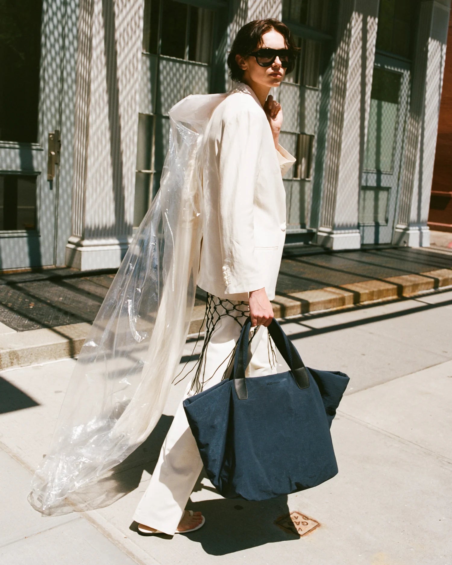 Woman holding a navy bag on a city street
