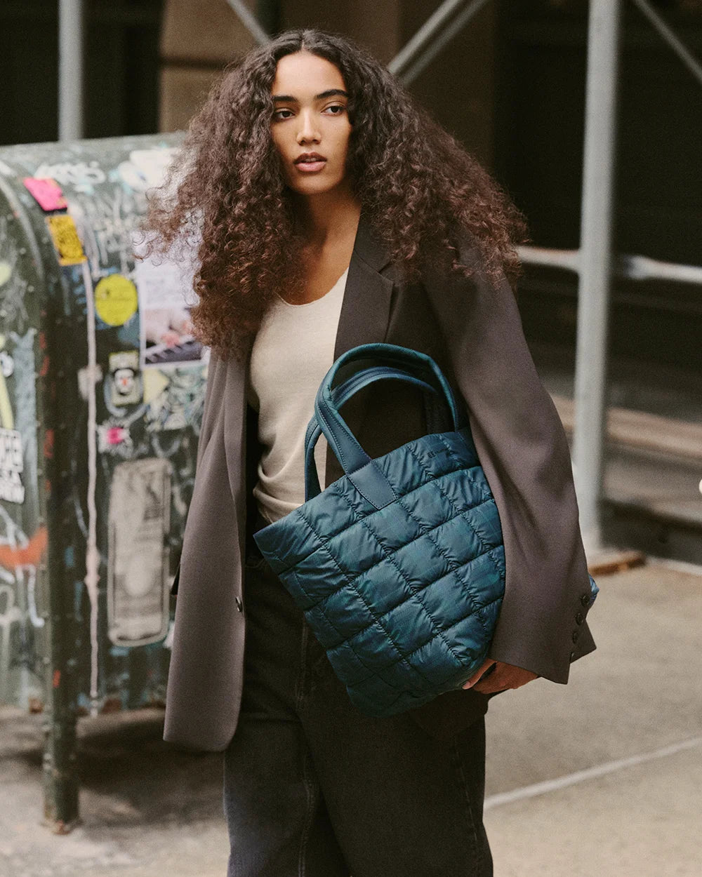 Woman holding a quilted VEE COLLECTIVE Porter Tote bag in Ivy Plaid 