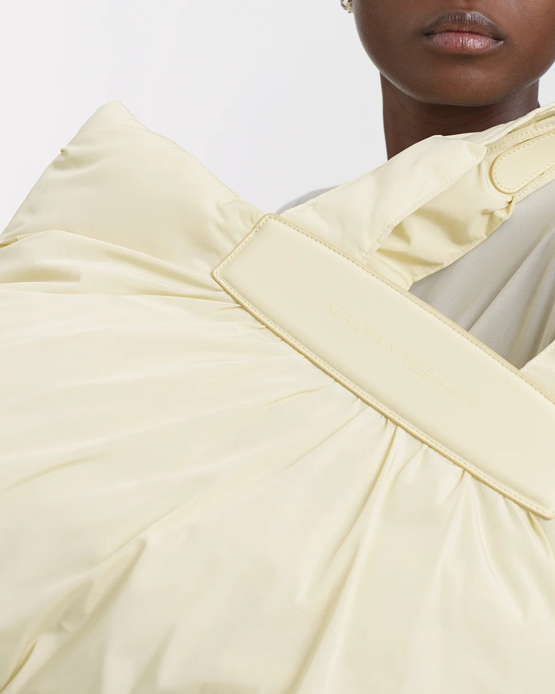 Close-up view of the Galvan x Vee Collective Caba Tote Medium in buttermilk, filling most of the frame. Only the lower half of the model’s face is visible, with the tote obscuring the rest of the upper body.