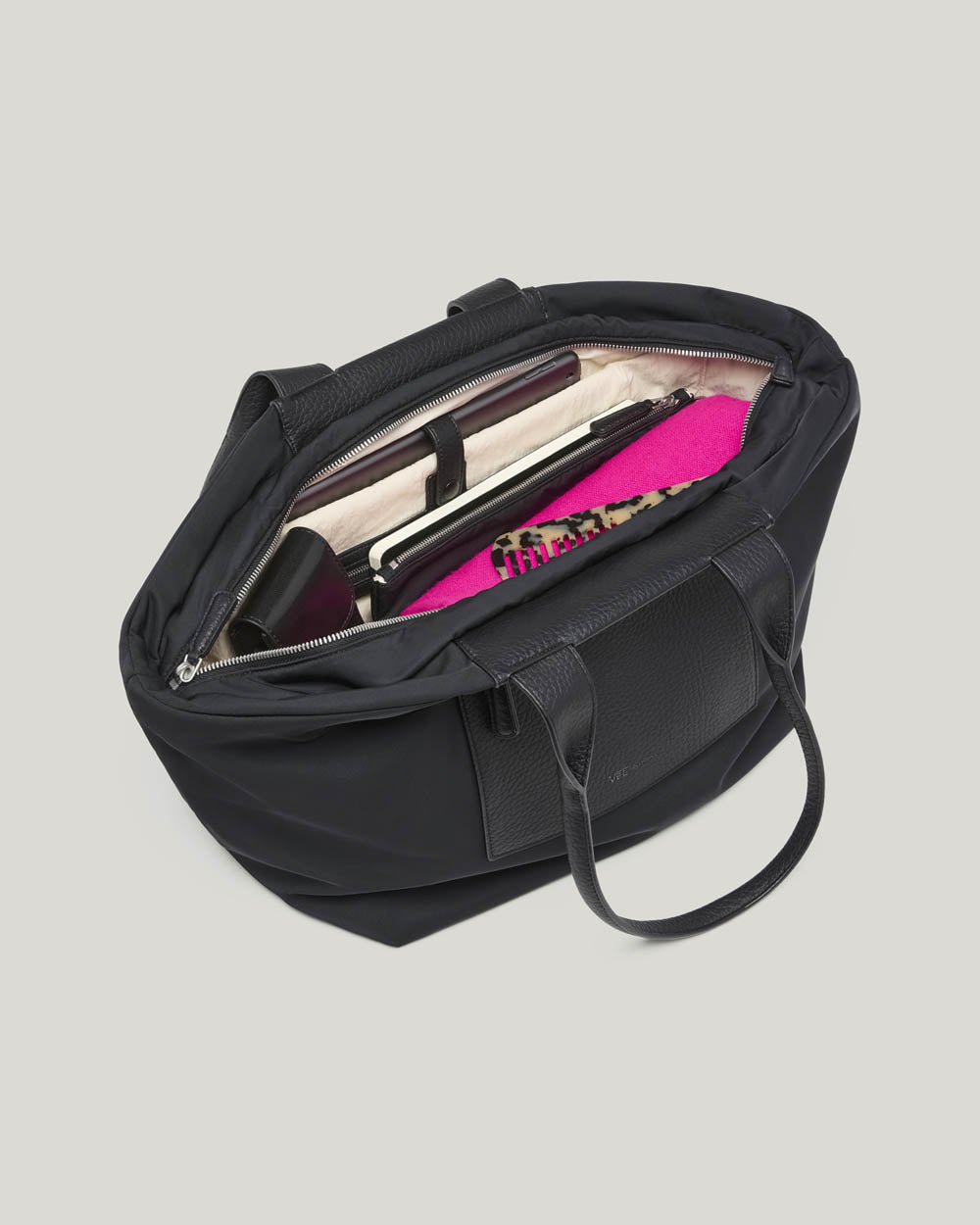 An image of Duo-Tote Black bag with dual top handles, shown from an overhead angle, featuring a cream coloured lining,  against a plain white background.