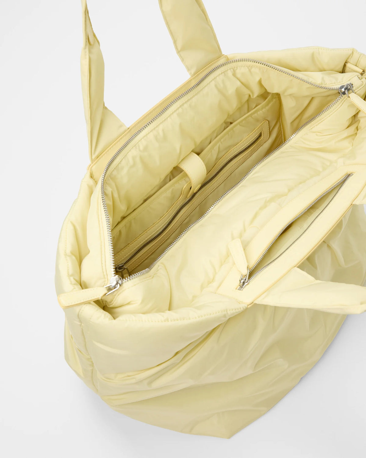 Angled, slightly overhead product photo of the Galvan x Vee Collective Caba Medium Bag in buttermilk, shown open to display the interior.