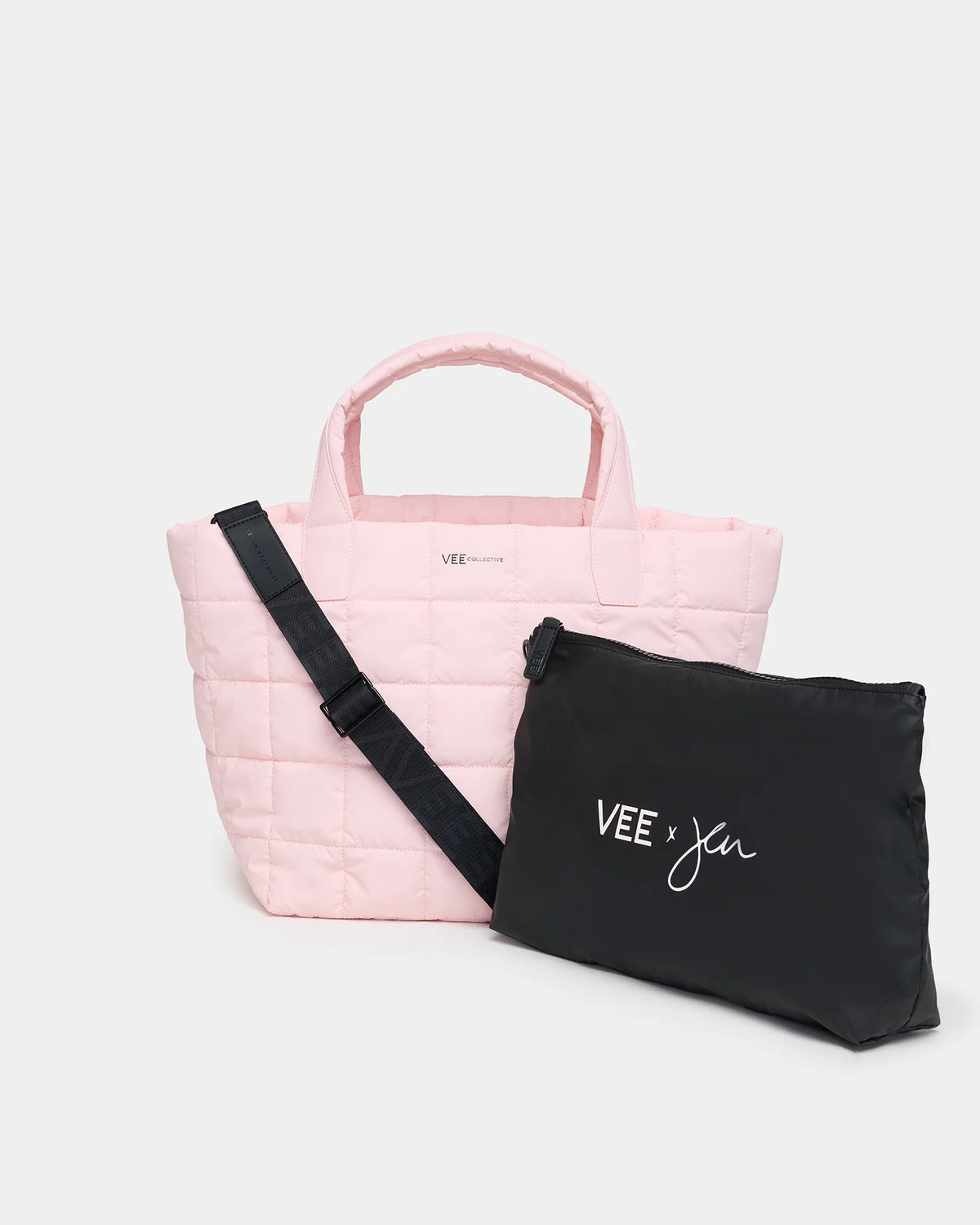 A soft pink quilted tote bag with two handles and a detachable black pouch featuring the text VEE x Jen in white. The totes versatile design makes it suitable for various occasions, from casual outings to work.
