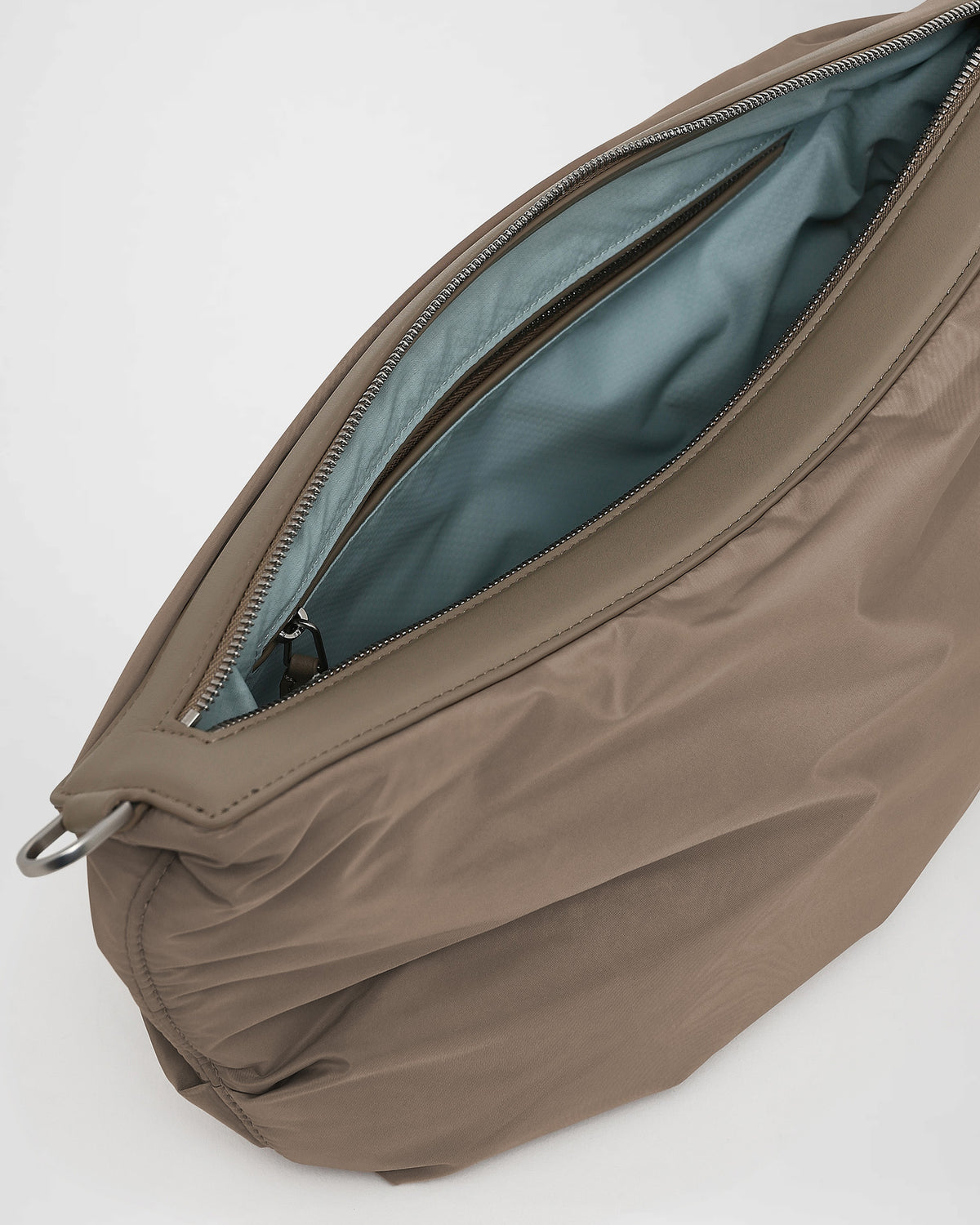 A close-up photo of the interior of an Caba banana, featuring black leather zipper pulls and a black zippered pocket with silver-tone metal zippers.