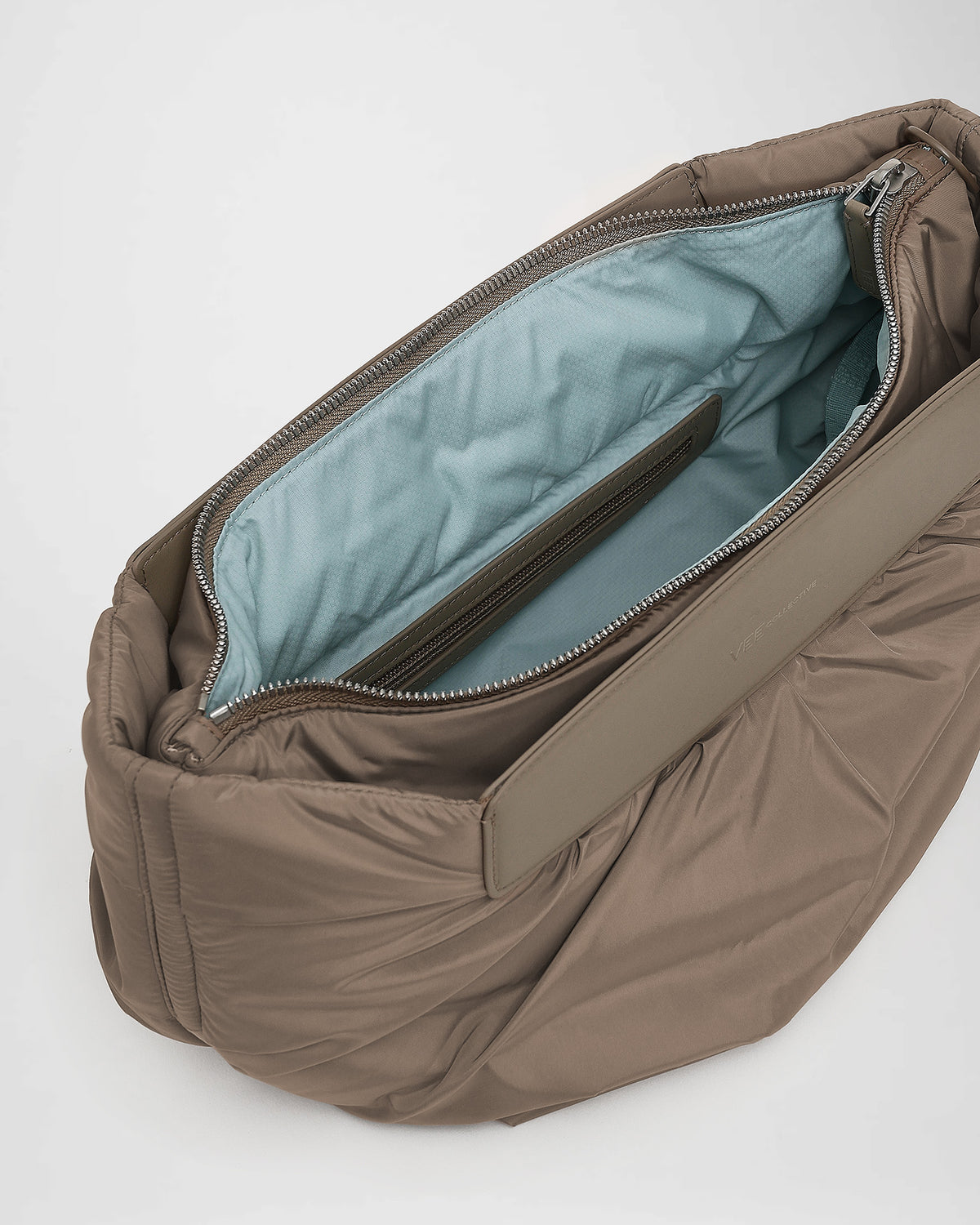 A close-up photo of the interior of an Caba clutch banana, zippered pocket with silver-tone metal zippers.