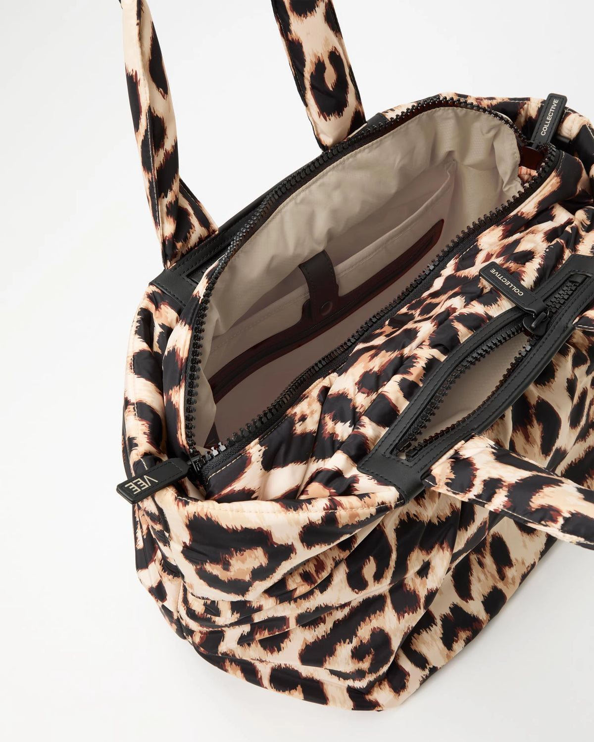 Leopard print handbag with beige interior lining and black zippers 