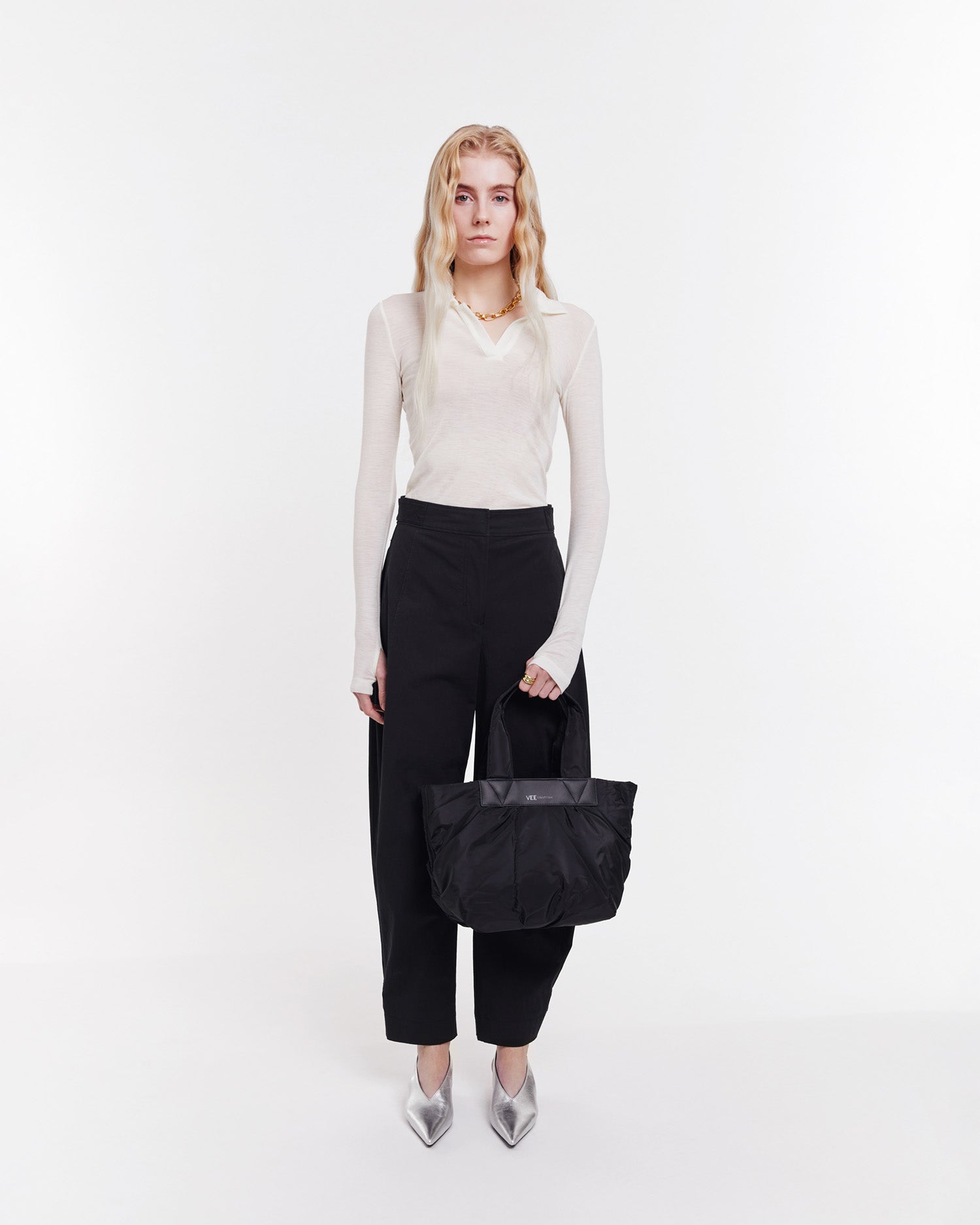 Small black tote bag made from waterproof and sustainable materials, designed for versatility and durability. Ideal for work and everyday use, combining practical functionality with eco-friendly style in a compact design.