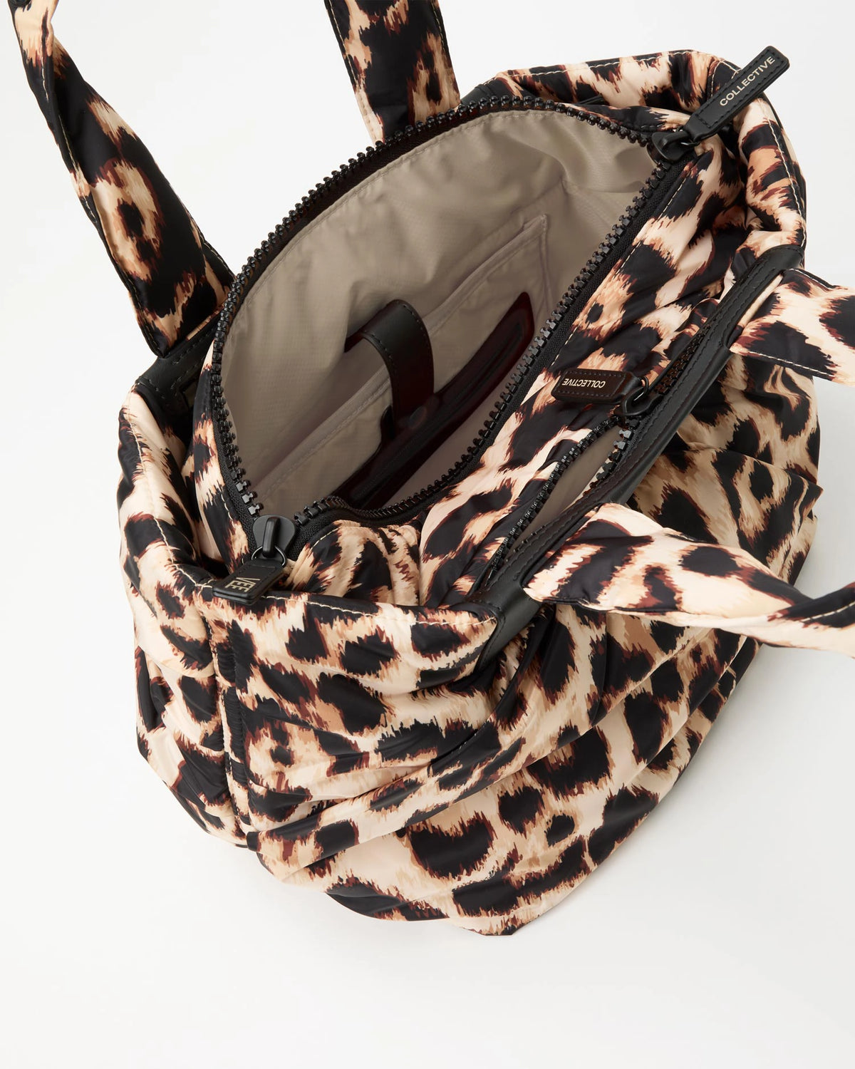 Leopard print tote bag with beige interior lining on a white background
