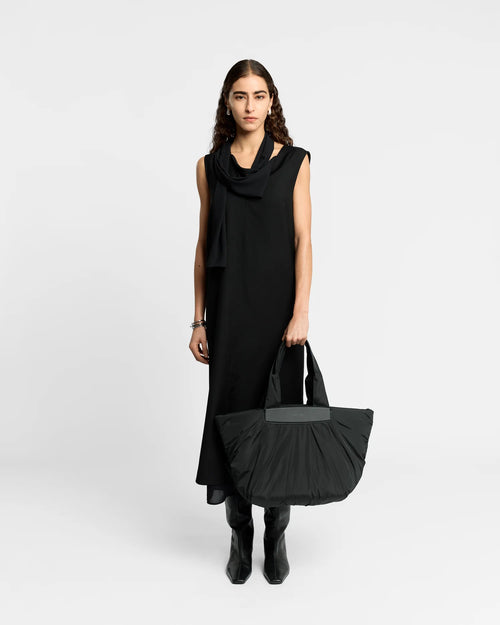 Woman wearing a clean outfit holding the Vee Collective Caba Tote Bag Medium in Black, shown against a clean background.