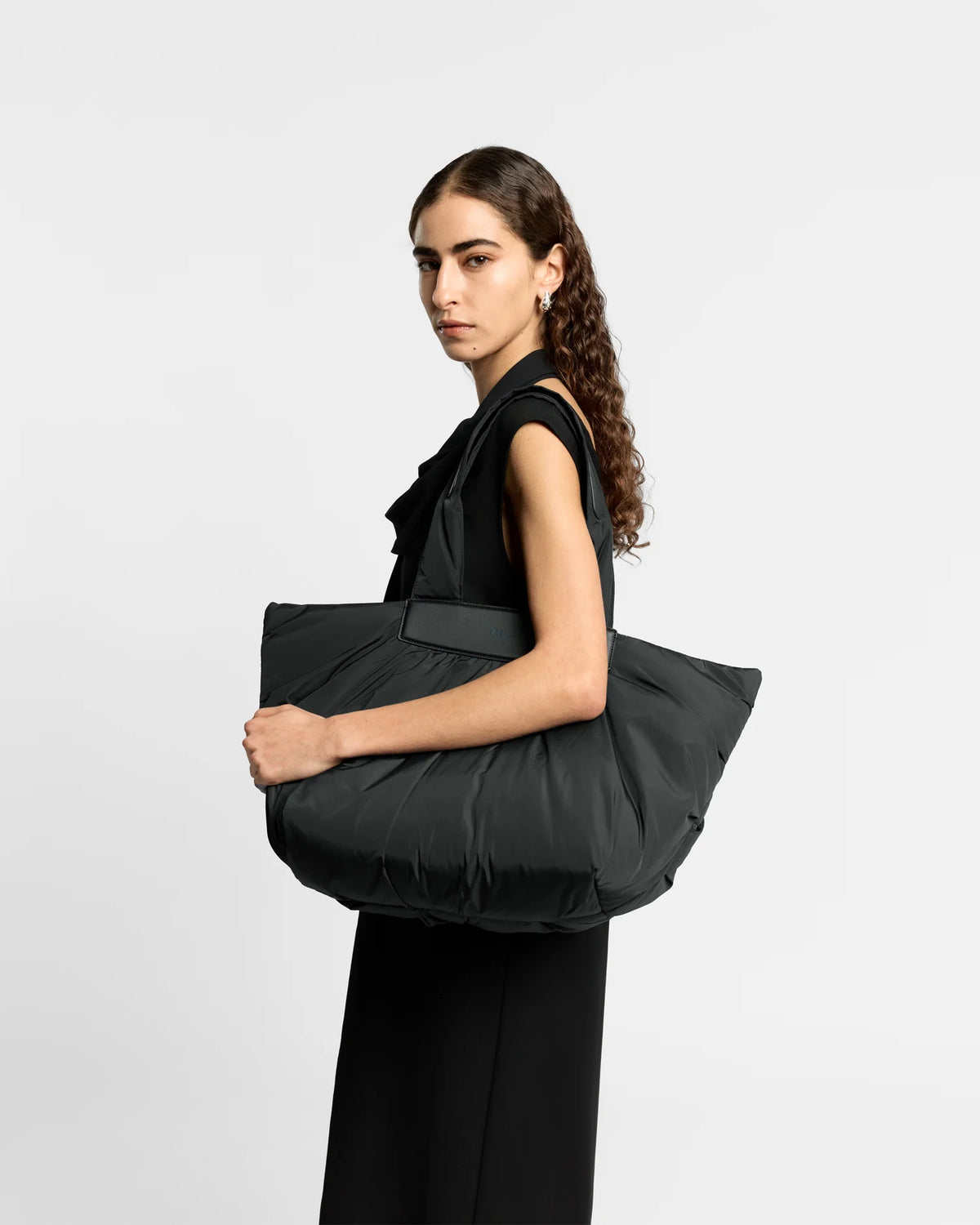 Woman wearing a clean outfit holding the Vee Collective Caba Tote Bag Medium in Black, shown against a clean background.
