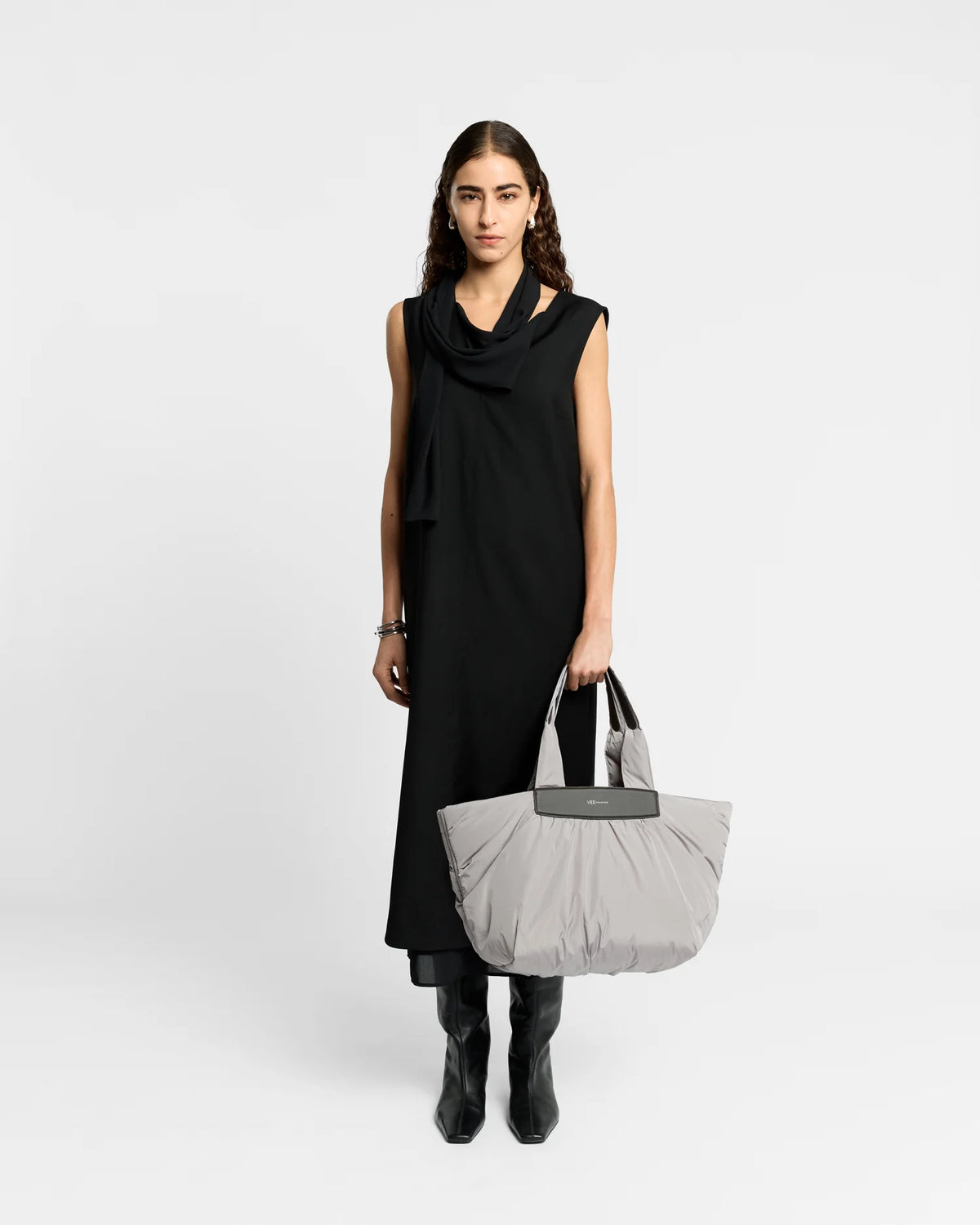 Woman wearing a clean outfit holding the Vee Collective Caba Tote Bag Medium in Dove, shown against a clean background.