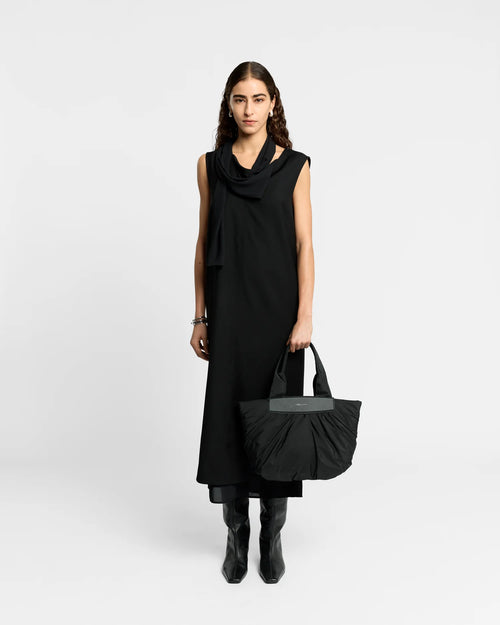 Woman wearing a clean outfit holding the Vee Collective Caba Tote Bag Small in Black, shown against a clean background.