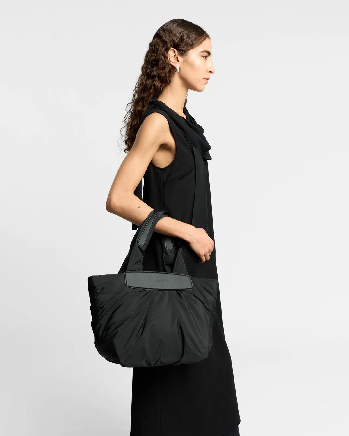 Woman wearing a clean outfit holding the Vee Collective Caba Tote Bag Small in Black, shown against a clean background.
