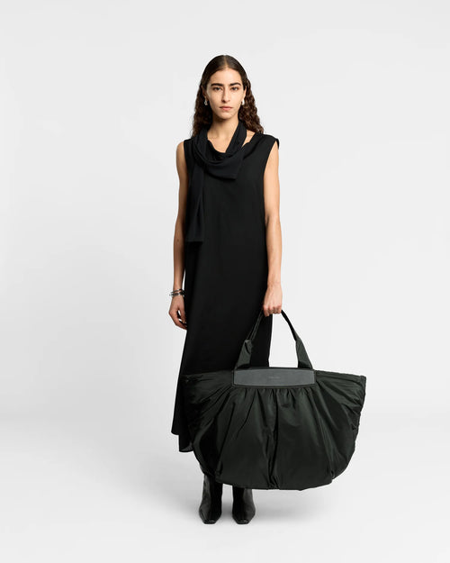 Woman wearing a clean outfit holding the Vee Collective Caba Weekender Tote Bag in Black, shown against a clean background.