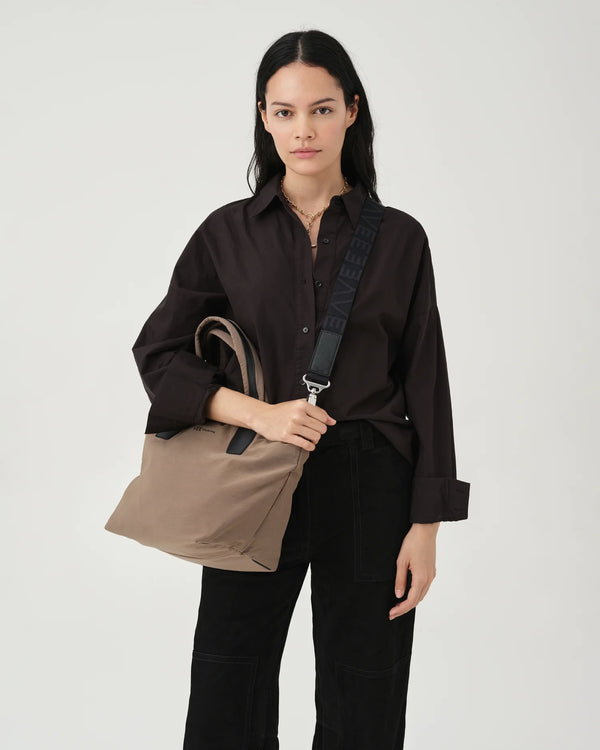 Woman in a beige trench coat carrying the Porter Essence Small Tote Bag in Mink Trench by Vee Collective against a plain studio background.