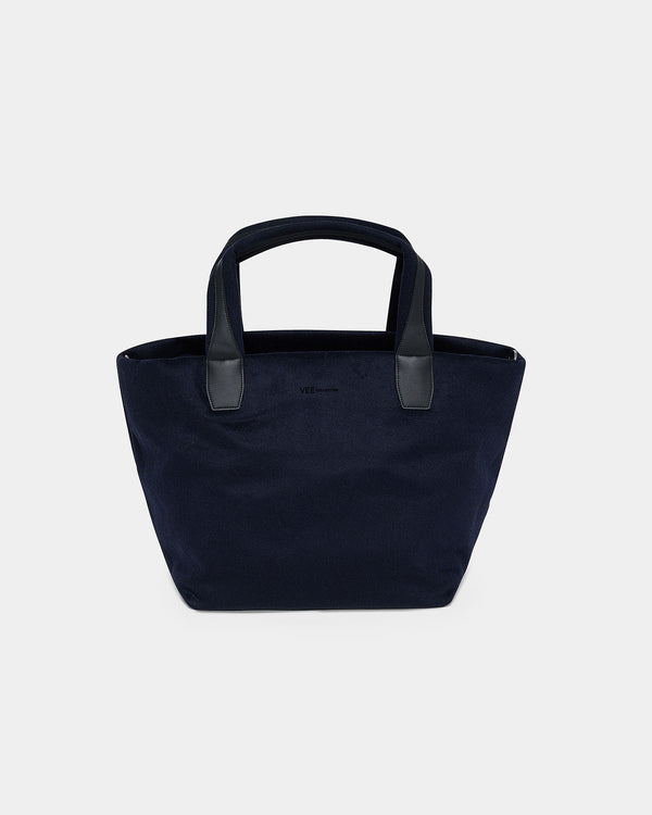 A navy blue canvas tote bag with dark gray handles, shown against a plain light gray background. c__1