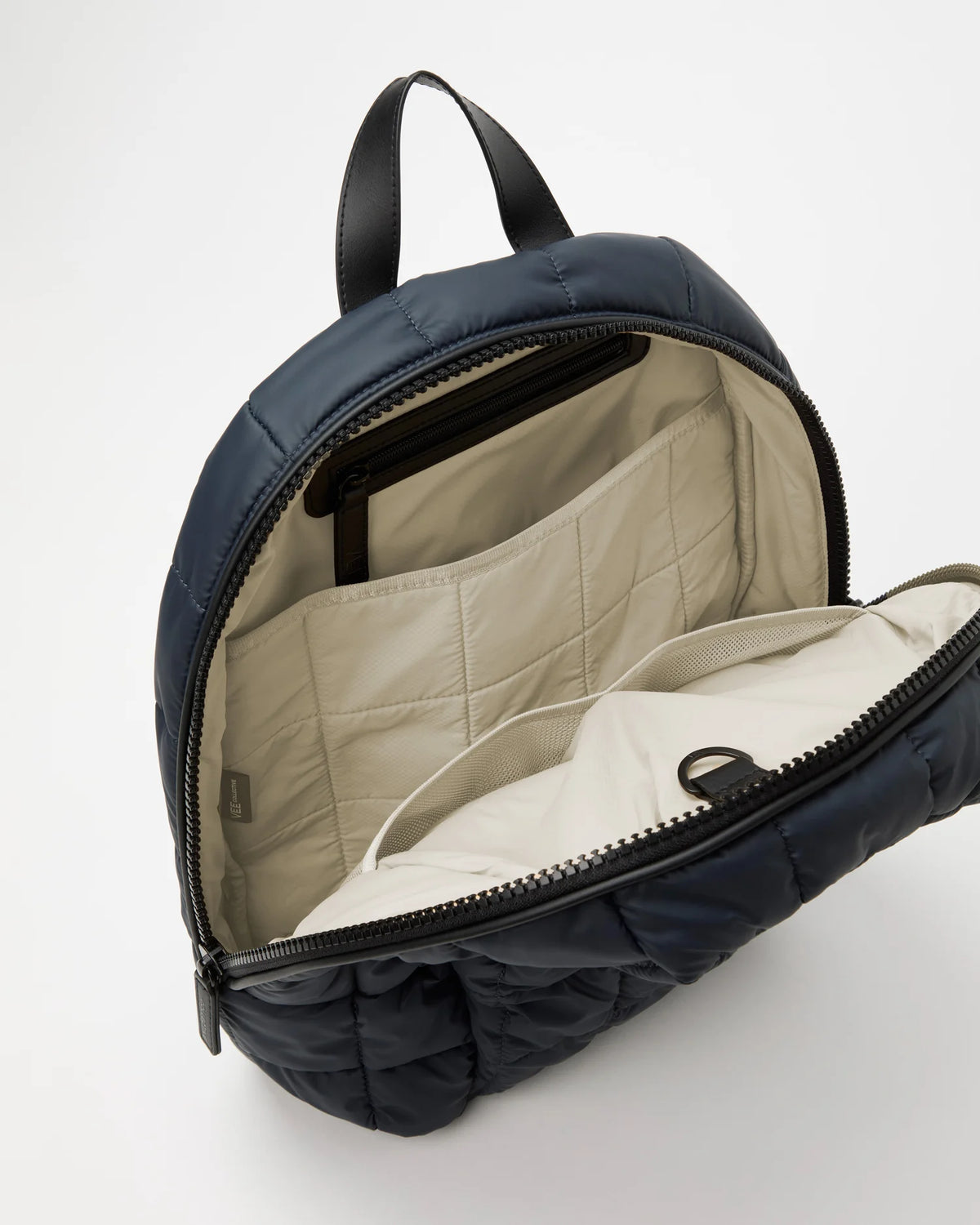 Open Vee Collective Porter Backpack in Dark Navy, showing the quilted exterior, top zipper, and interior compartments of the Backpack.