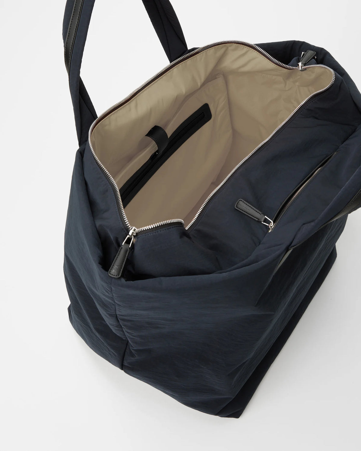 Navy Essence Weekender bag opened to show beige lining and interior zip pocket.