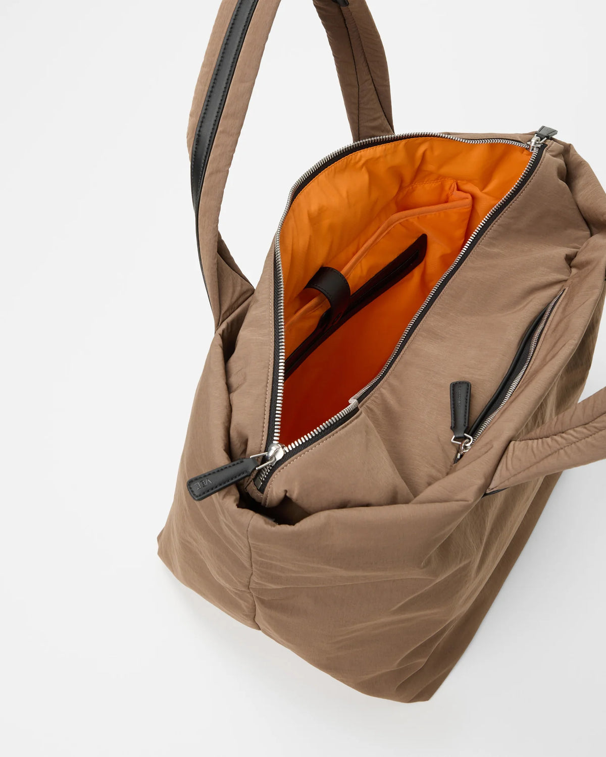 Open Vee Collective Porter Essence Medium in Mink Trench, showing the quilted exterior, top zipper, and orange interior of the Tote bag.