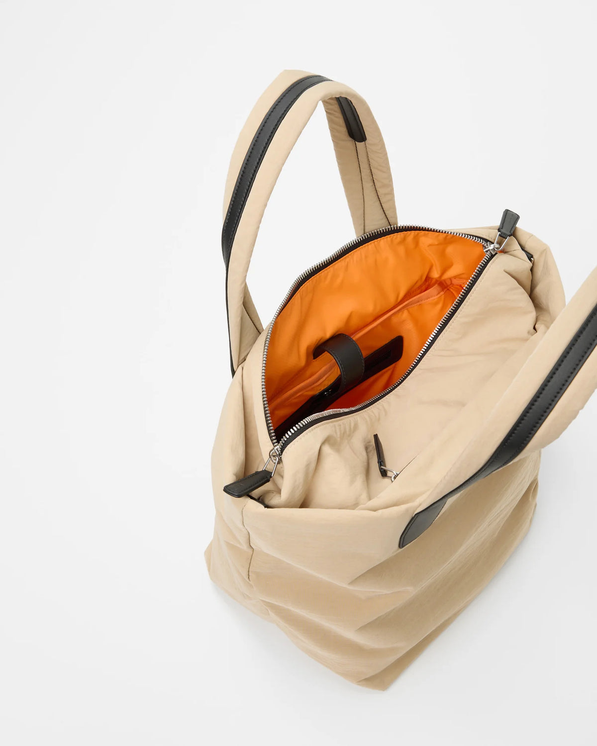 Open Vee Collective Porter Essence Small in Beige Trench, showing the quilted exterior, top zipper, and orange interior of the Tote bag.