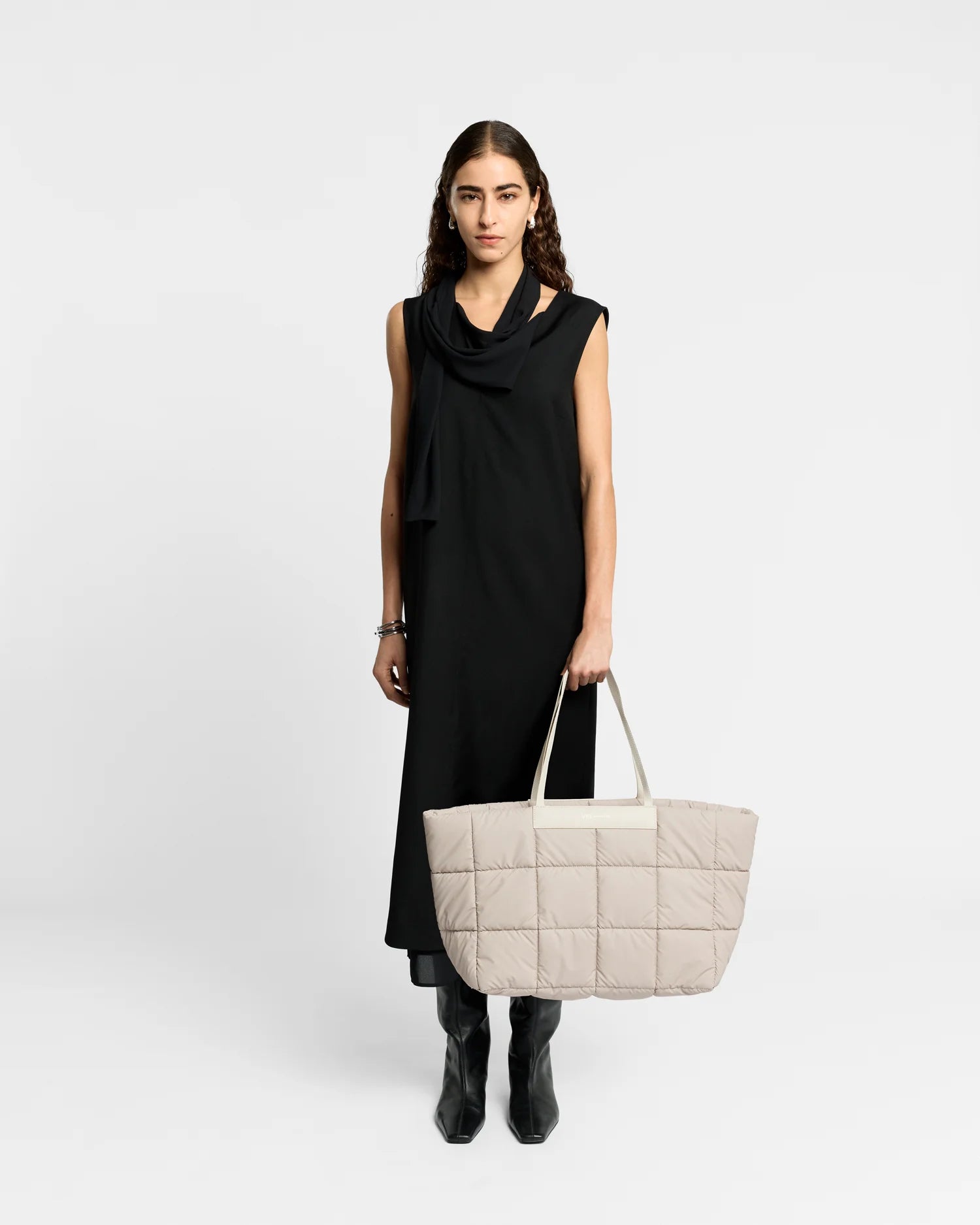 Woman wearing a clean outfit holding the Vee Collective Porter Marché Tote Bag in Soft Taupe, shown against a clean background.