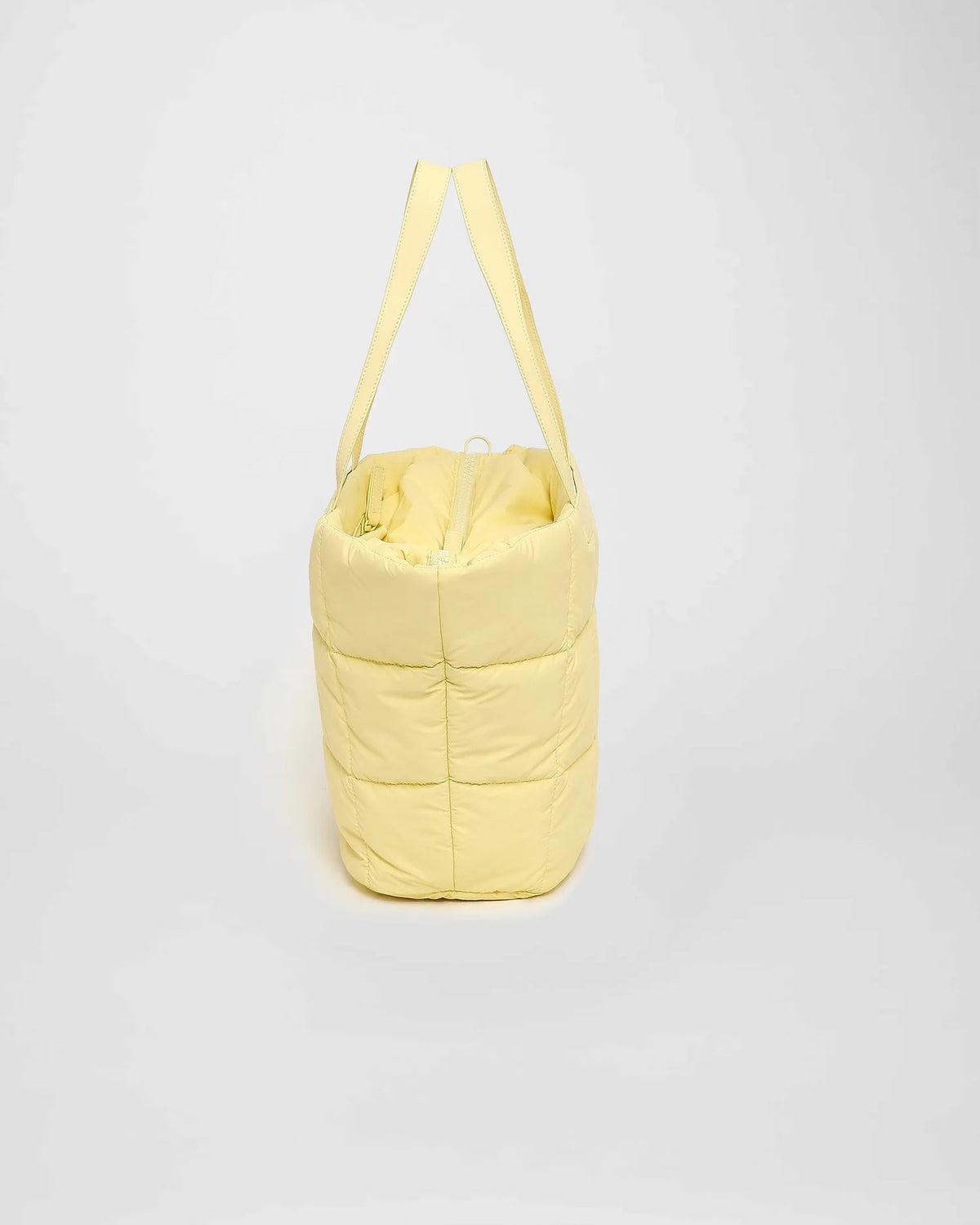A picture featuring the side view of a Porter Marche Bag in buttermilk displayed on a white background