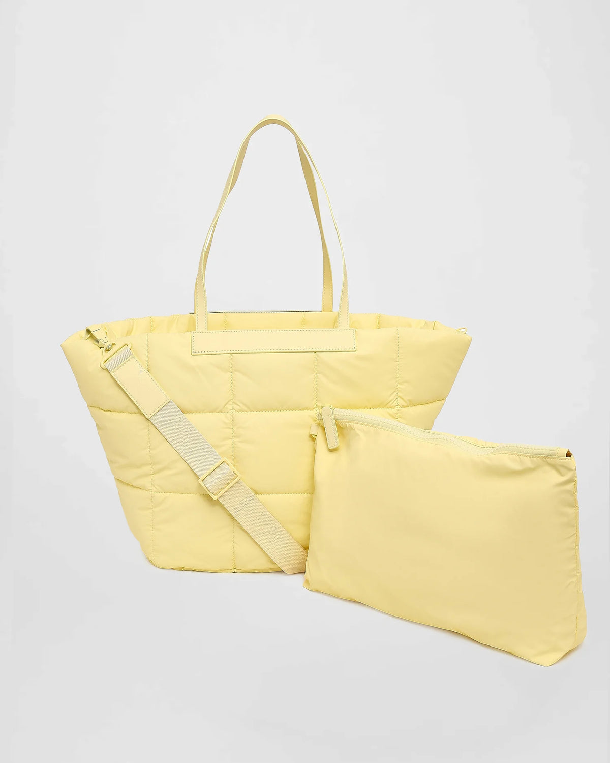 A picture featuring a Porter Marche Bag medium in buttermilk with a matching shoulder strap, shown next to a matching zippered pouch on a white background.