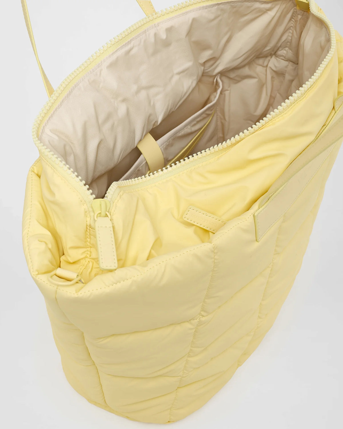 A close-up view of an open Porter Marche Bag in buttermilk with a visible zipper and interior on a white background.