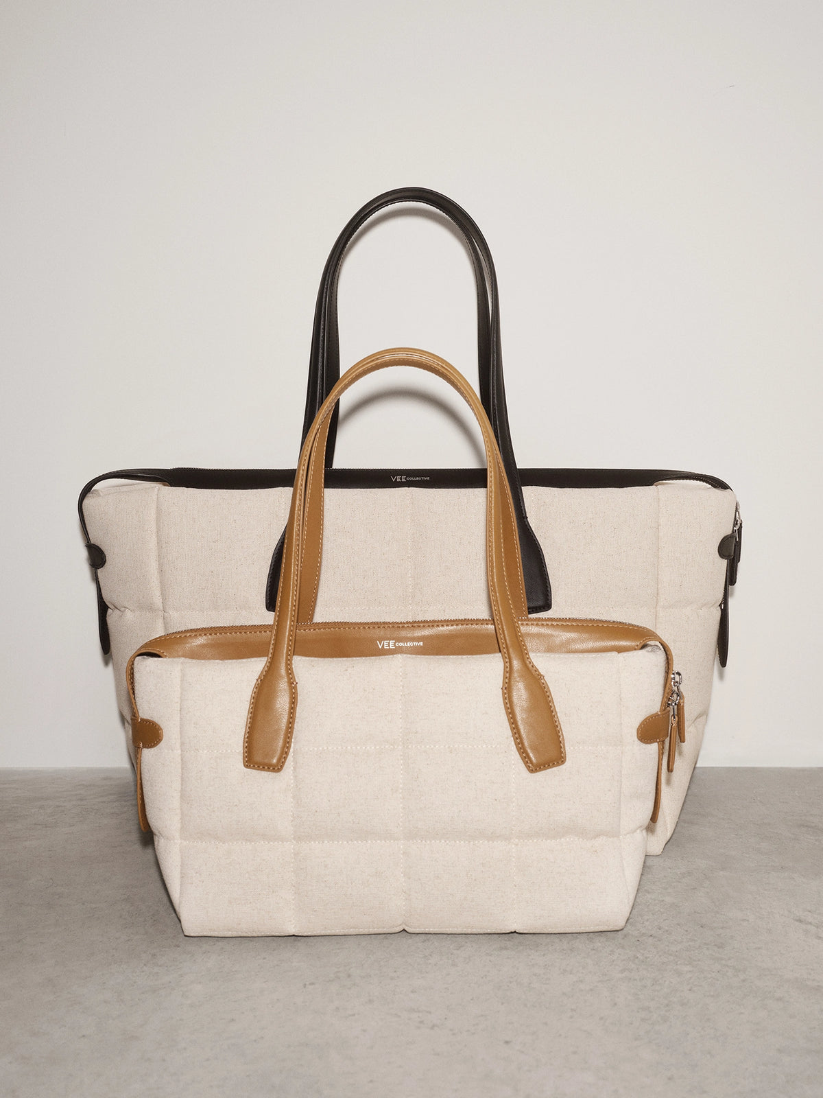 Tela Tote Large Natural Tan Canvas bag with dark brown leather handles visible at the top.
