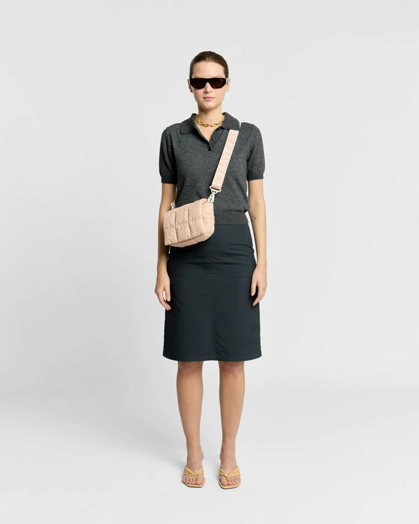 Woman wearing the Porter Messenger Mini Bag in Cameo Rose by Vee Collective crossbody, styled with a minimalistic outfit against a clean studio background.