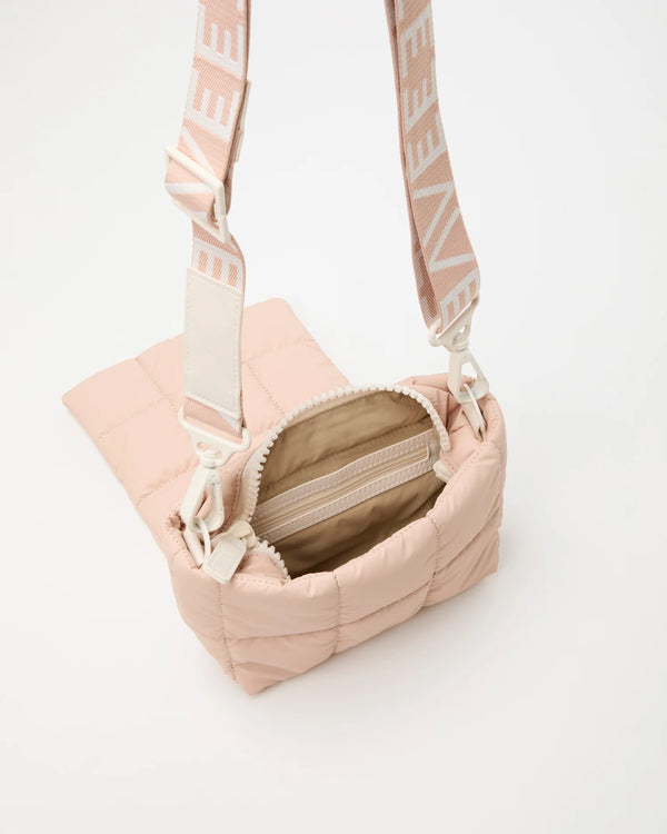 Open Vee Collective Porter Messenger Mini Bagl in Cameo Rose, showing the quilted exterior, top zipper, and interior compartments of the tote bag.
