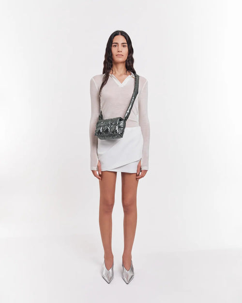 Model wearing a metallic grey Porter Messenger Mini crossbody bag worn across the chest