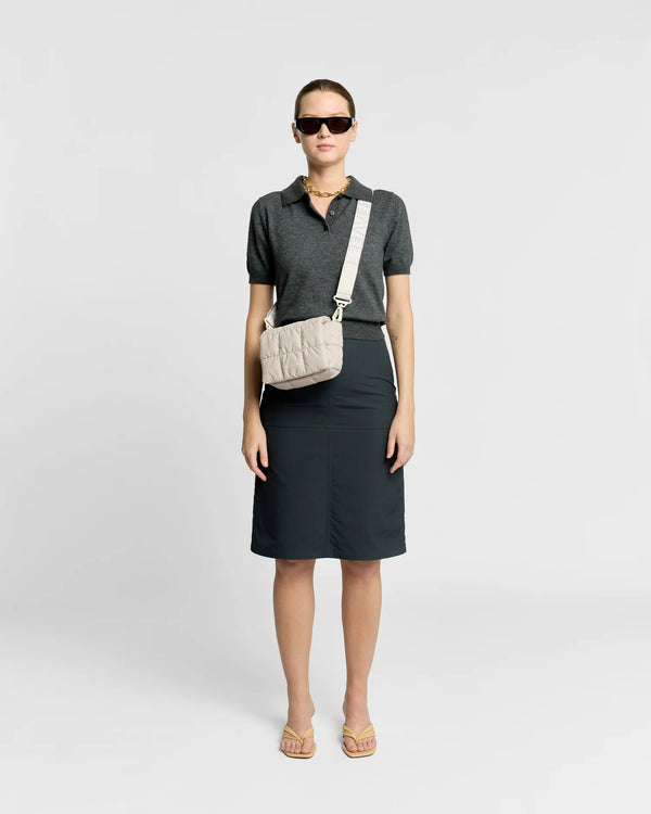 Woman wearing the Porter Messenger Mini Bag in Soft Taupe by Vee Collective crossbody, styled with a minimalistic outfit against a clean studio background.