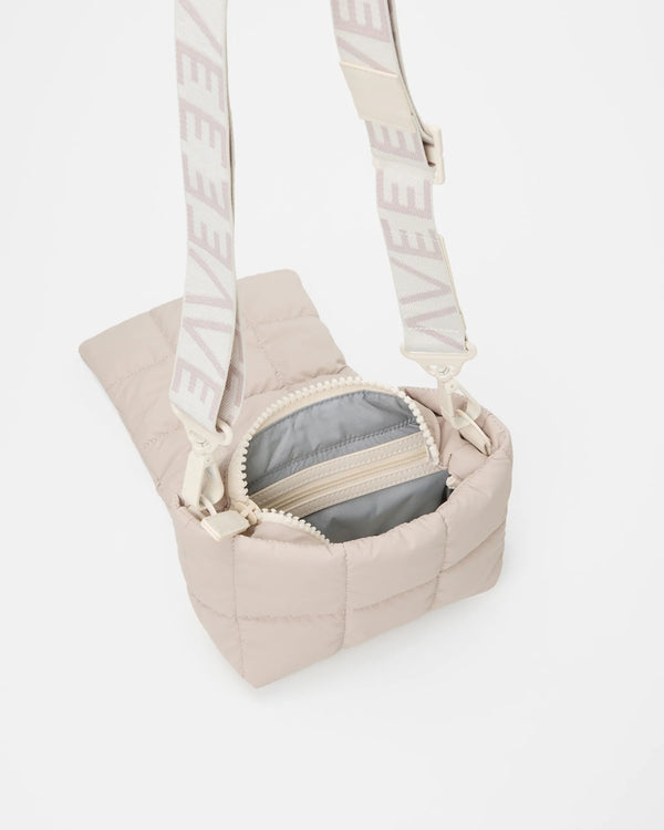 Open Vee Collective Porter Messenger Mini Bag  in Soft Taupe, showing the quilted exterior, top zipper, and interior compartments of the tote bag.