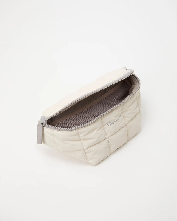 Open Vee Collective Porter Sling Bag in Barely Beige, showing the quilted exterior, top zipper, and interior compartments of the tote bag.