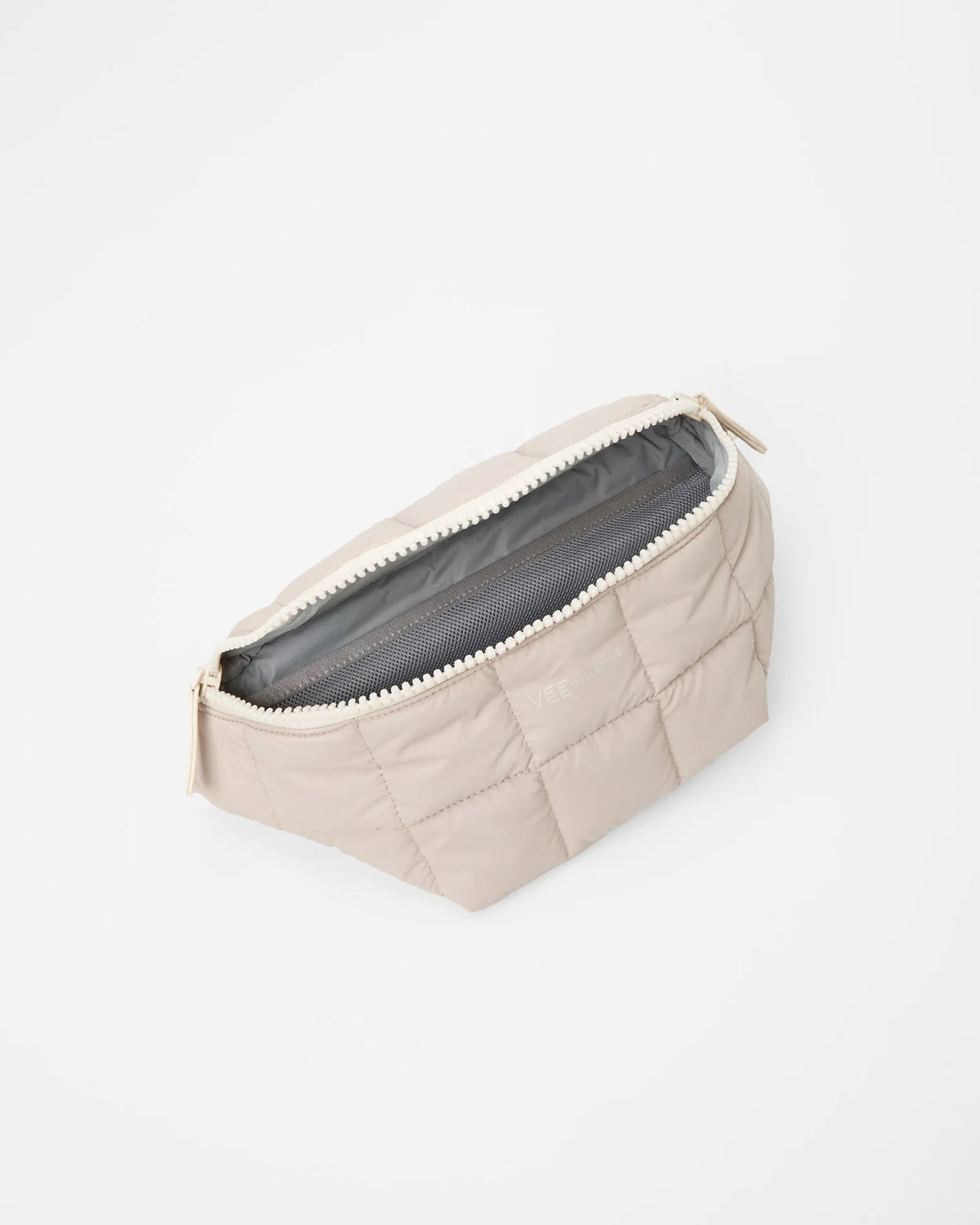 Open Vee Collective Porter Sling Bag in Soft Taupe, showing the quilted exterior, top zipper, and interior compartments of the tote bag.