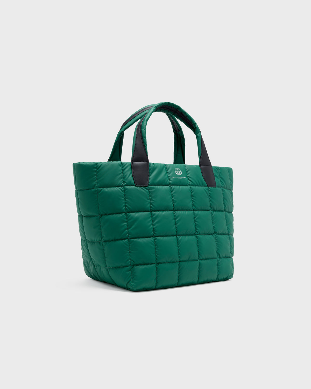 A green quilted puffer tote bag with dark green handles, shown from a three-quarter angle against a light gray background.