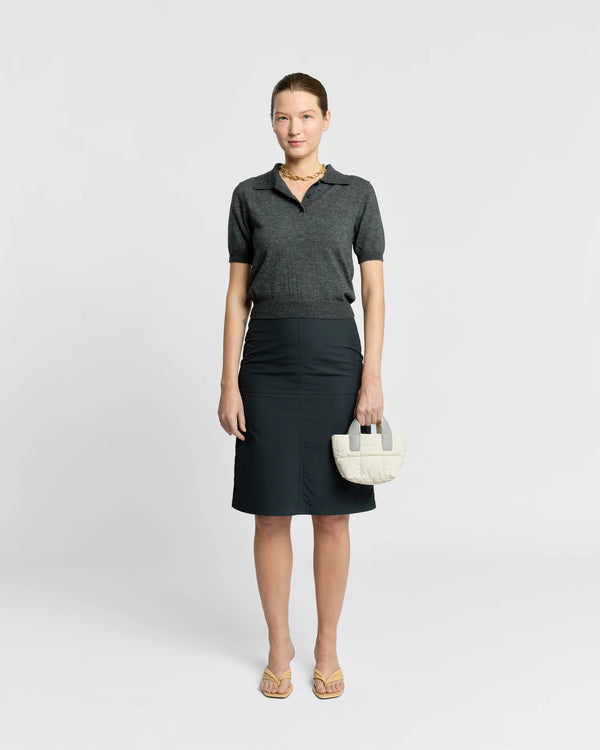 On-body picture of a woman holding the Micro Porter Tote Bag in Barely Beige by Vee Collective, wearing a minimalistic outfit against a clean studio background.