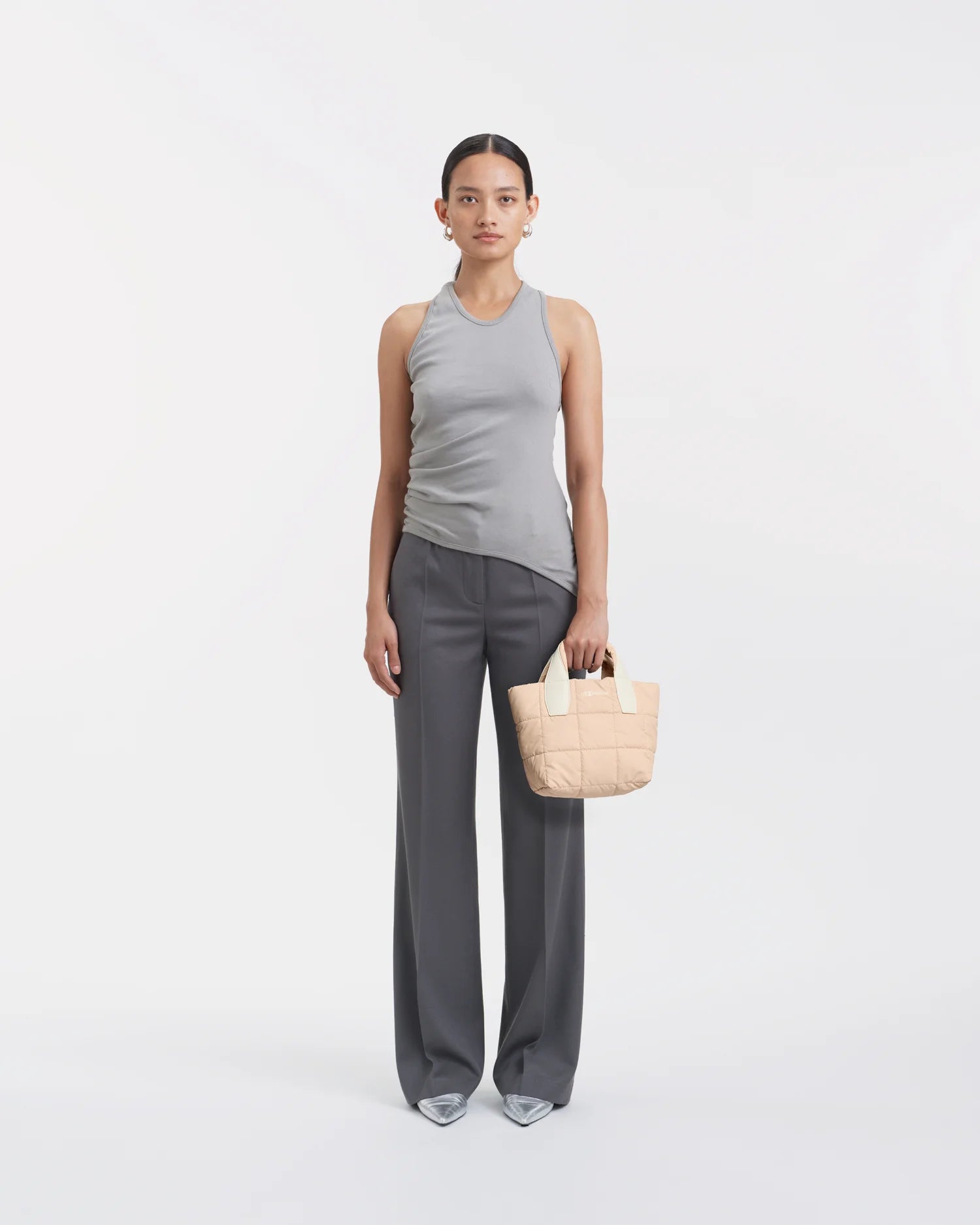 Woman wearing a clean outfit holding the Vee Collective Porter Tote Bag Mini in Cameo Rose, shown against a clean background.