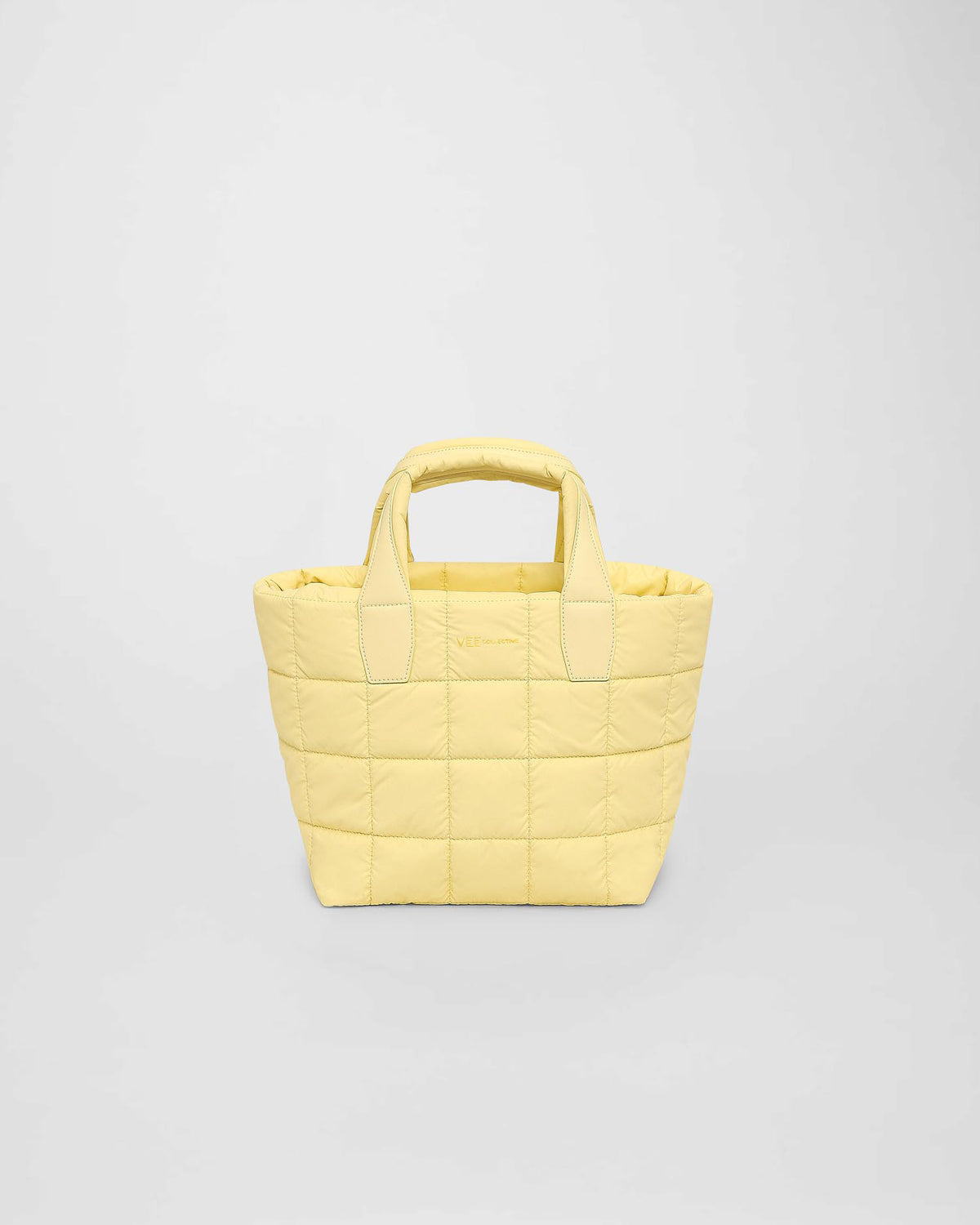 A Porter tote bag in a soft buttermilk yellow color features a puffy square pattern. It has sturdy handles for easy carrying and is suitable for daily use or casual outings.