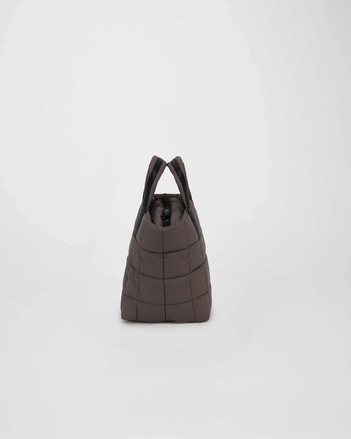 A picture featuring the side view of a small Porter Tote Bag in mink with a puffy square pattern, two sturdy handles, and a zippered top on a white background
