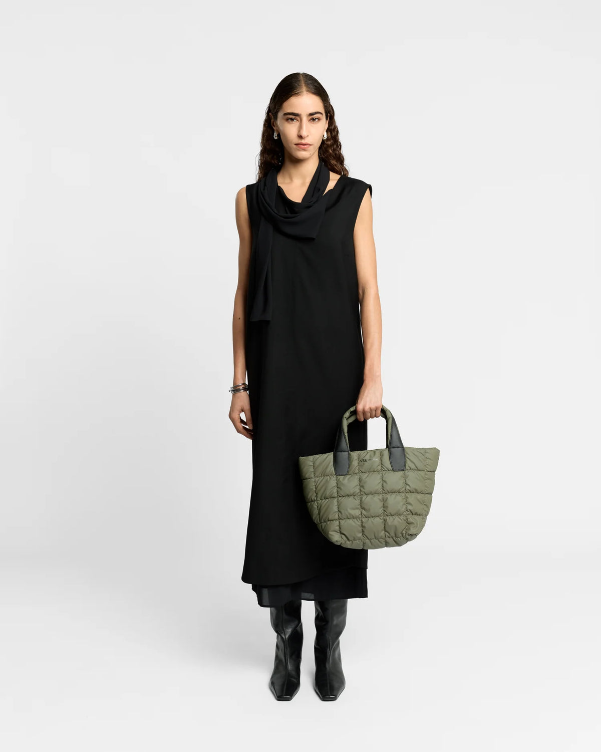 Woman wearing a clean outfit holding the Vee Collective Porter Tote Bag Small in Moss, shown against a clean background.