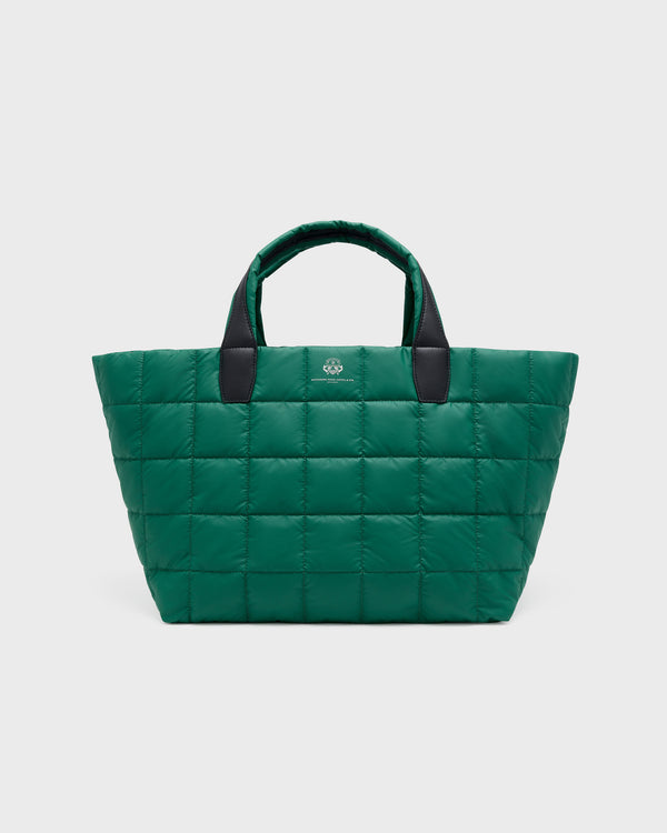 A green quilted puffer tote bag with black handles and a small silver logo on the front, photographed against a light gray background. c__1