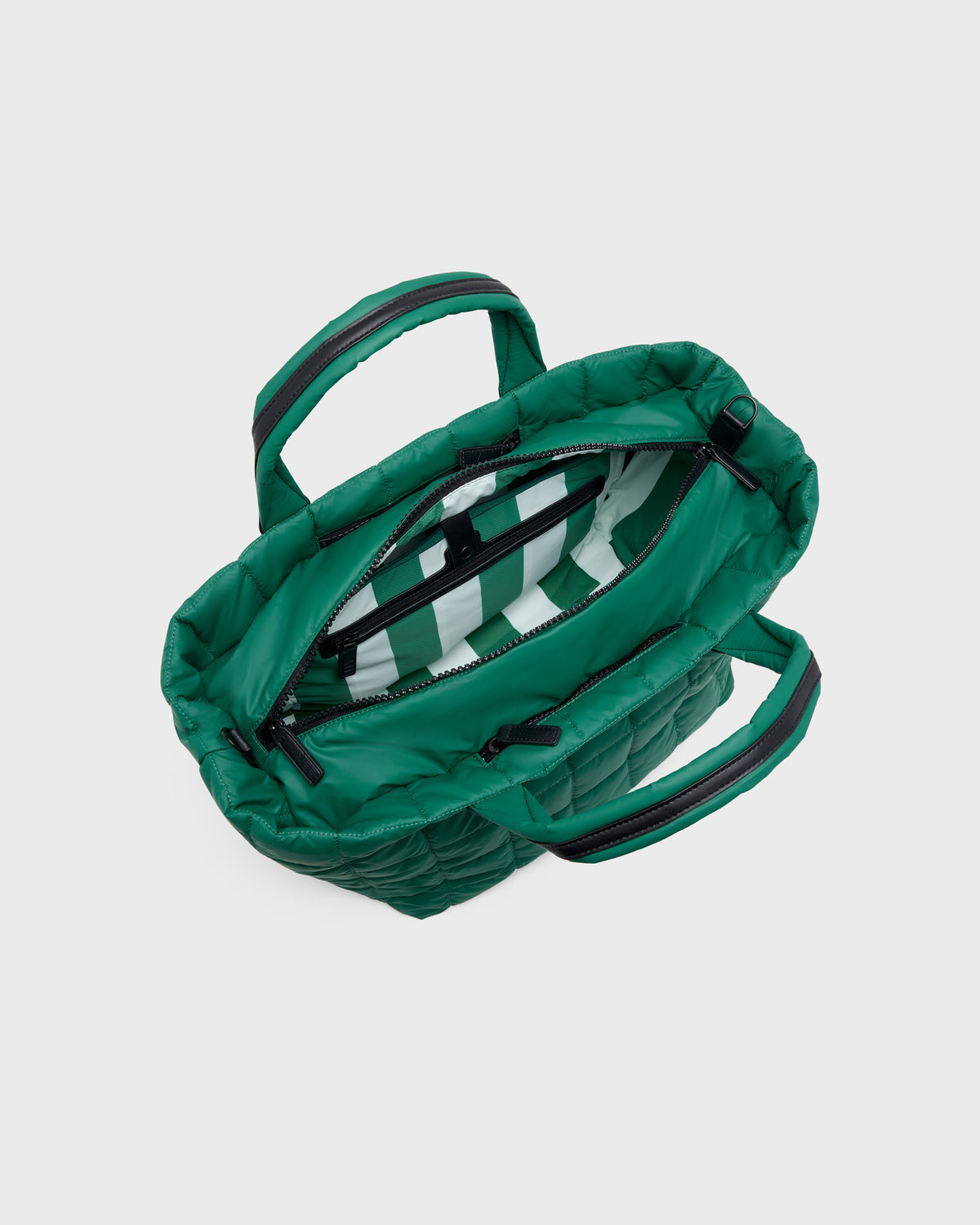A green quilted puffer handbag shown from an overhead angle, open to reveal a striped interior lining and black zipper details, set against a plain light gray background.