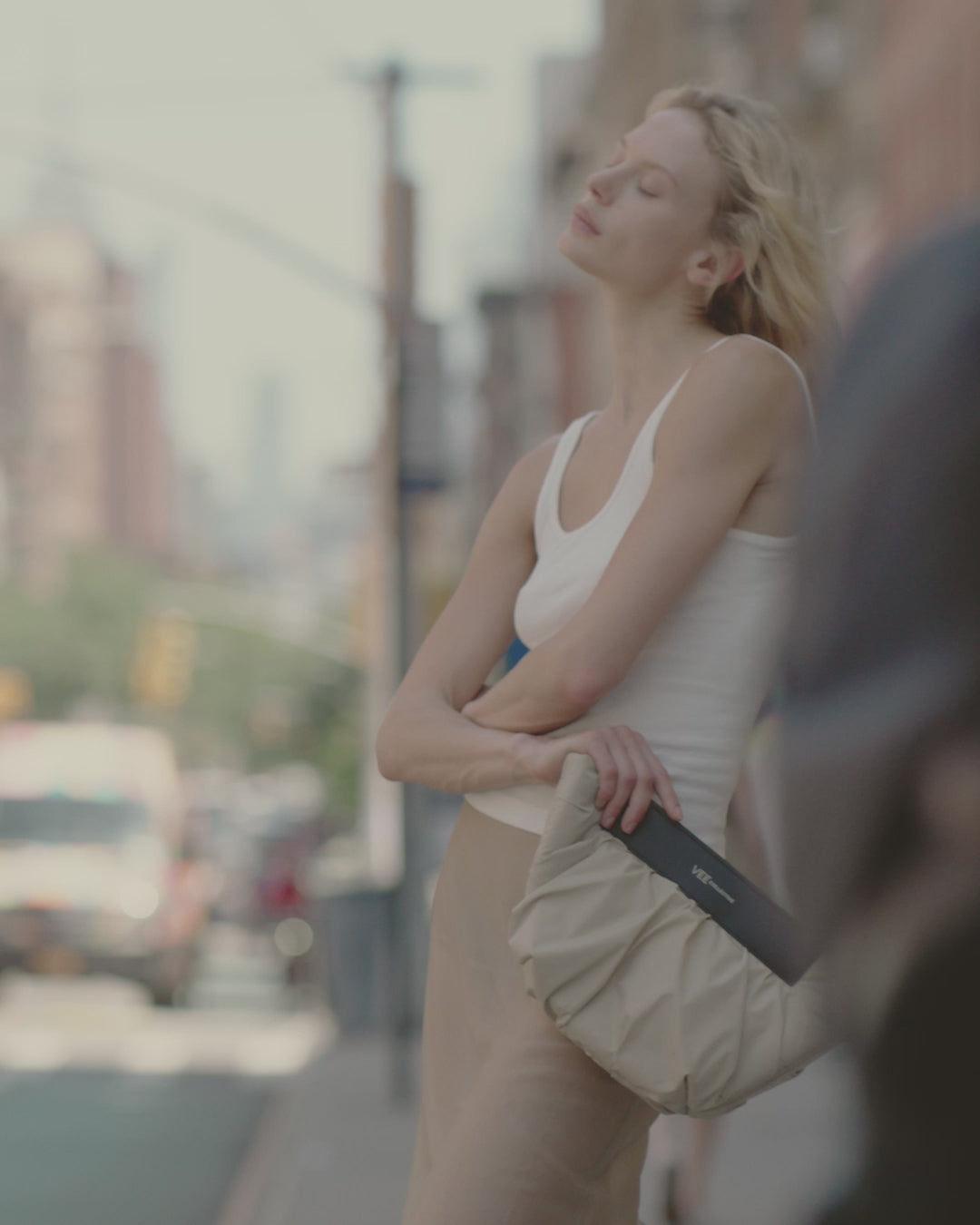 Video of a woman wearing the Caba Clutch Bag in Beige by Vee Collective.