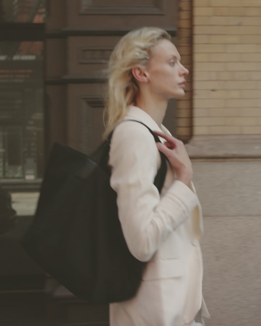 Woman in motion walking through NYC, carrying Vee Collective Porter Essence Mini and Olive bags.